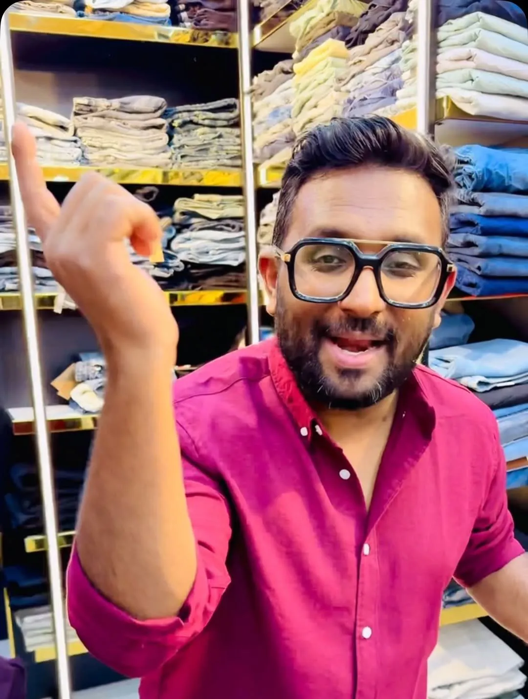 A Trendz team member in a berry shirt inside the store, shelves of folded denim behind